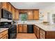 Modern kitchen featuring wood cabinets, sleek black appliances, and granite countertops at 423 Mephisto Cir, Lawrenceville, GA 30046