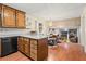 Open concept kitchen with granite counters, wood cabinets, and adjacent dining area and view to the living room at 423 Mephisto Cir, Lawrenceville, GA 30046