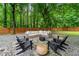 Serene backyard features a stone firepit area with comfortable seating and lush greenery at 6655 Manchester Pl, Cumming, GA 30040