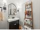 Charming powder room showcasing a black vanity, decorative ladder, and elegant wall sconces at 6655 Manchester Pl, Cumming, GA 30040
