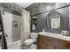 Stylish bathroom with patterned wallpaper, a shower, and a wood vanity with a marble countertop at 6655 Manchester Pl, Cumming, GA 30040
