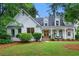 Charming painted brick home with manicured lawn, dormers, inviting front porch and double-door front entry at 6655 Manchester Pl, Cumming, GA 30040