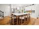 Spacious kitchen showcasing an island with barstool seating, white cabinets, stainless steel appliances and hardwood floors at 6655 Manchester Pl, Cumming, GA 30040