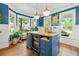 Unique island with seating, beverage fridge, wood top, and natural light coming from the bay windows at 6655 Manchester Pl, Cumming, GA 30040