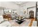 Open-concept living room with hardwood floors, large windows, neutral decor, and access to the kitchen at 6655 Manchester Pl, Cumming, GA 30040