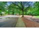Neighborhood park featuring a playground and basketball court surrounded by mature trees at 6655 Manchester Pl, Cumming, GA 30040