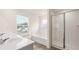 Bright bathroom featuring a large tub, enclosed shower, and natural light at 291 Sandy Oak Dr, Loganville, GA 30052