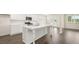 Modern kitchen featuring an island, stainless steel appliances, white cabinets, and hardwood floors at 291 Sandy Oak Dr, Loganville, GA 30052