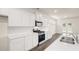 Modern kitchen featuring stainless steel appliances, white cabinets and a gray stone countertop at 291 Sandy Oak Dr, Loganville, GA 30052