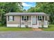 Cozy single-story home boasts neutral siding, black shutters, and a white-railed front porch at 104 Gilreath Rd, Cartersville, GA 30121