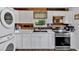 Kitchen featuring stainless steel appliances, white cabinets, and stacked washer/dryer at 104 Gilreath Rd, Cartersville, GA 30121