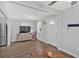 Bright living room with laminate floors showcasing a TV, shelving, and a view of the front door at 104 Gilreath Rd, Cartersville, GA 30121