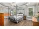 Bright main bedroom featuring a tray ceiling, four-poster bed, and hardwood floors at 270 Meadow View Dr, Grayson, GA 30017