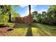 A lush, green backyard surrounds a charming brick home with mature trees at 2390 Tiffany Pl, Decatur, GA 30035