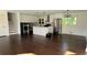Spacious living room with hardwood floors, white walls, and a modern kitchen with stainless steel appliances at 2390 Tiffany Pl, Decatur, GA 30035