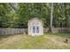 View of the outdoor shed in the backyard with fencing and mature trees at 263 Chandler Ridge Dr, Douglasville, GA 30134