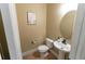 Neutral powder room featuring a pedestal sink, round mirror, and modern fixtures; clean and efficient design at 366 Highbranch Cir, Lawrenceville, GA 30044