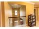 Upstairs hallway featuring wood railing, decorative lighting, and a view to the front door at 366 Highbranch Cir, Lawrenceville, GA 30044