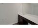 Bathroom vanity with white countertop, wood cabinetry and large mirror at 10814 Wheeler Trce, Hampton, GA 30228