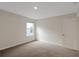 A sunlit bedroom featuring neutral walls, carpet flooring, and a large window at 10814 Wheeler Trce, Hampton, GA 30228