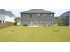 Large backyard featuring healthy green grass and a newly planted tree at 1612 Fuma Leaf Way, Mcdonough, GA 30253