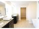 Bathroom featuring double sinks, granite counters, walk-in closet and standalone tub at 1612 Fuma Leaf Way, Mcdonough, GA 30253