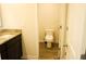 Bathroom featuring granite countertop, dark cabinets, vinyl floors and a toilet at 1612 Fuma Leaf Way, Mcdonough, GA 30253
