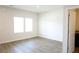 Bright bedroom featuring wood-look floors, two windows, neutral walls, and a white door at 1612 Fuma Leaf Way, Mcdonough, GA 30253