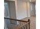 Second floor hallway with neutral carpeting and decorative iron railings at 1612 Fuma Leaf Way, Mcdonough, GA 30253