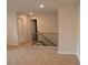 Upstairs hallway with neutral carpet and a wood and iron railing at 1612 Fuma Leaf Way, Mcdonough, GA 30253