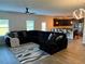 Open-concept living room featuring a dark sofa, a modern kitchen and contemporary lighting at 1612 Fuma Leaf Way, Mcdonough, GA 30253