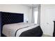 Main bedroom with tufted headboard, window with curtains, and contemporary bedroom furniture at 1612 Fuma Leaf Way, Mcdonough, GA 30253