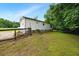 Side exterior showcasing the back entrance, surrounded by lush greenery and a fenced yard at 891 Wooten Ct, Canton, GA 30114