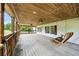 Spacious covered back porch with a ceiling fan and a wood swing to relax and enjoy the wooded views at 891 Wooten Ct, Canton, GA 30114