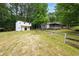 Large backyard with a white building with windows, a wood fence, and a swing hanging from the fence at 891 Wooten Ct, Canton, GA 30114