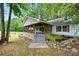View of the covered front porch, stone path and lush greenery of this cozy, single Gathering home at 891 Wooten Ct, Canton, GA 30114