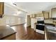 Open kitchen with wood-look flooring and bright white appliances overlooking a living space at 891 Wooten Ct, Canton, GA 30114