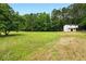 Wide green meadow with forest in the background and a white outbuilding with windows, a beautiful view at 891 Wooten Ct, Canton, GA 30114