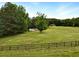 Scenic view of the property with a fenced pasture and house in the background at 891 Wooten Ct, Canton, GA 30114