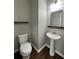 Half-bathroom featuring a sleek pedestal sink and a decorative mirror at 944 Reap Ln, Lawrenceville, GA 30043