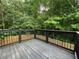 Back deck showcasing a wooden deck surrounded by trees and a wooden fence at 944 Reap Ln, Lawrenceville, GA 30043