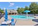 Community pool with blue umbrellas, chairs, and mushroom fountain, surrounded by trees and a clubhouse at 944 Reap Ln, Lawrenceville, GA 30043