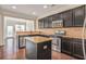 Open concept kitchen with dark wood cabinets and stainless steel appliances at 11686 Davenport Ln, Alpharetta, GA 30005