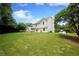 A spacious backyard view of the home with lush green lawn and mature trees at 455 Saddle Bow Dr, Lawrenceville, GA 30046