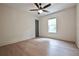 Bright bedroom features a ceiling fan, light wood floors, and a window letting in natural light at 455 Saddle Bow Dr, Lawrenceville, GA 30046