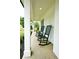 Charming porch with two green rocking chairs and white brick columns at 455 Saddle Bow Dr, Lawrenceville, GA 30046