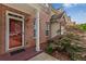 Charming brick entryway with a glass paneled red door and decorative plants creating a warm, inviting welcome at 2924 Greyhawk Ln, Cumming, GA 30040