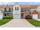 Charming townhome featuring a one car garage, red front door, manicured lawn, and inviting curb appeal at 2924 Greyhawk Ln, Cumming, GA 30040