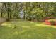 Sprawling green backyard with a wooden fence and deck shaded by a pergola at 3866 Teresa Sw Ter, Lilburn, GA 30047