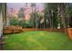 Large backyard with a wooden fence, mature trees, and a well-maintained lawn at 5023 Rockborough Trl, Norcross, GA 30071